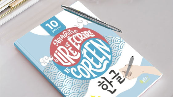 Livre posé sur un bureau avec un stylo et une paire de lunettes. Le livre est  intitulé 10 jours pour apprendre à lire et écrire le coréen