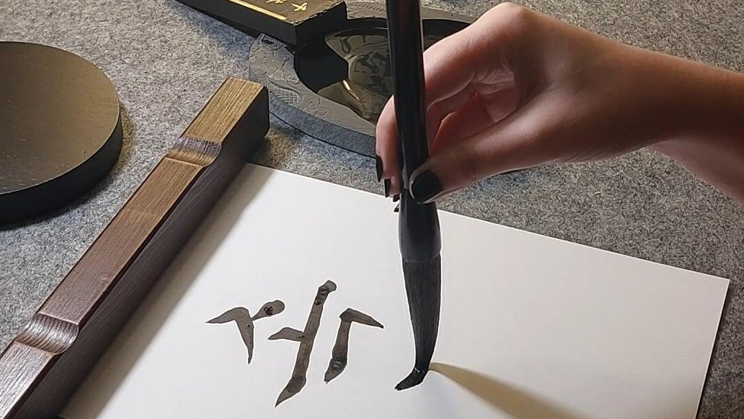Gros plan sur une main calligraphiant le mot Sokcho