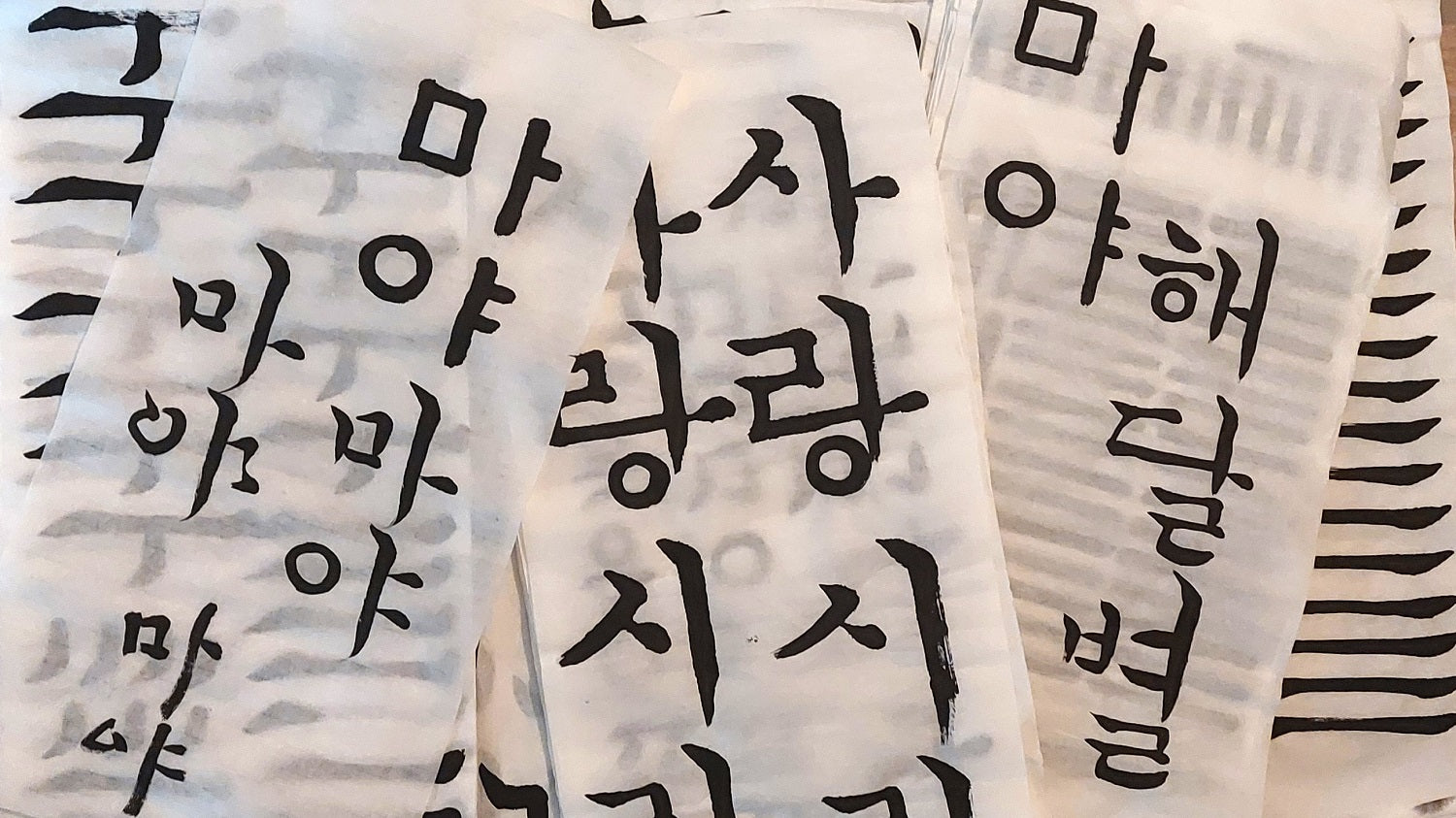 Photo de plusieurs essais de calligraphie en hangeul.