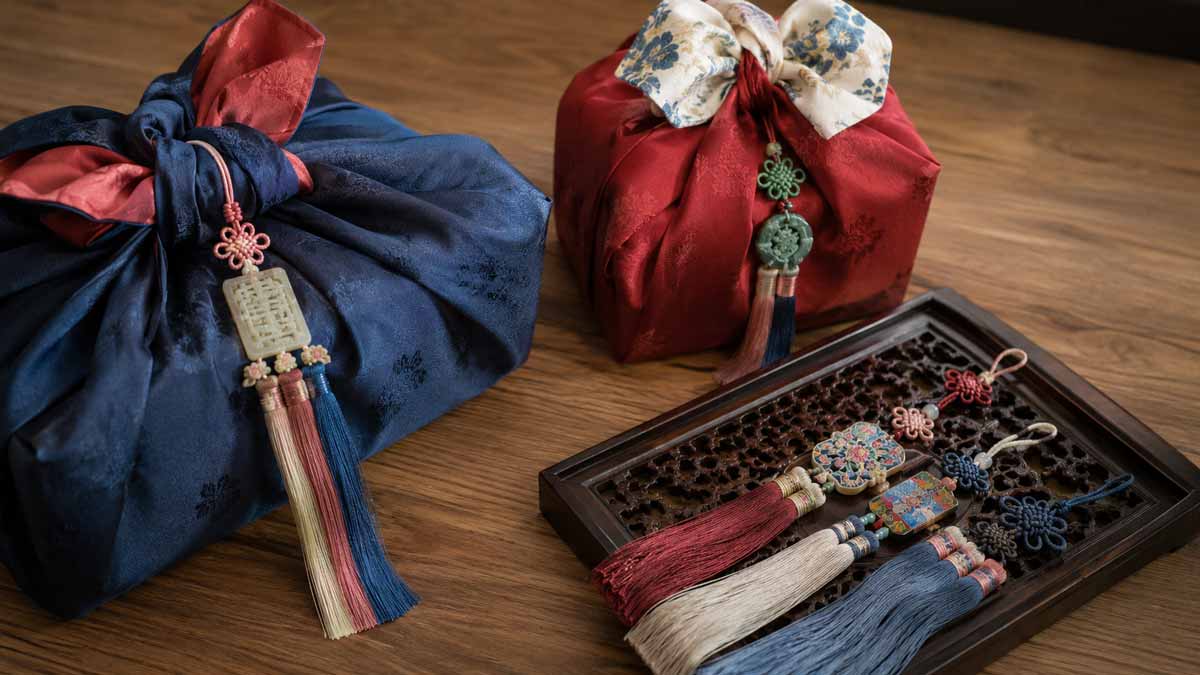 Photo de deux paquets cadeaux coréens appelés bojagi et plusieurs noligae, les noeuds coréens