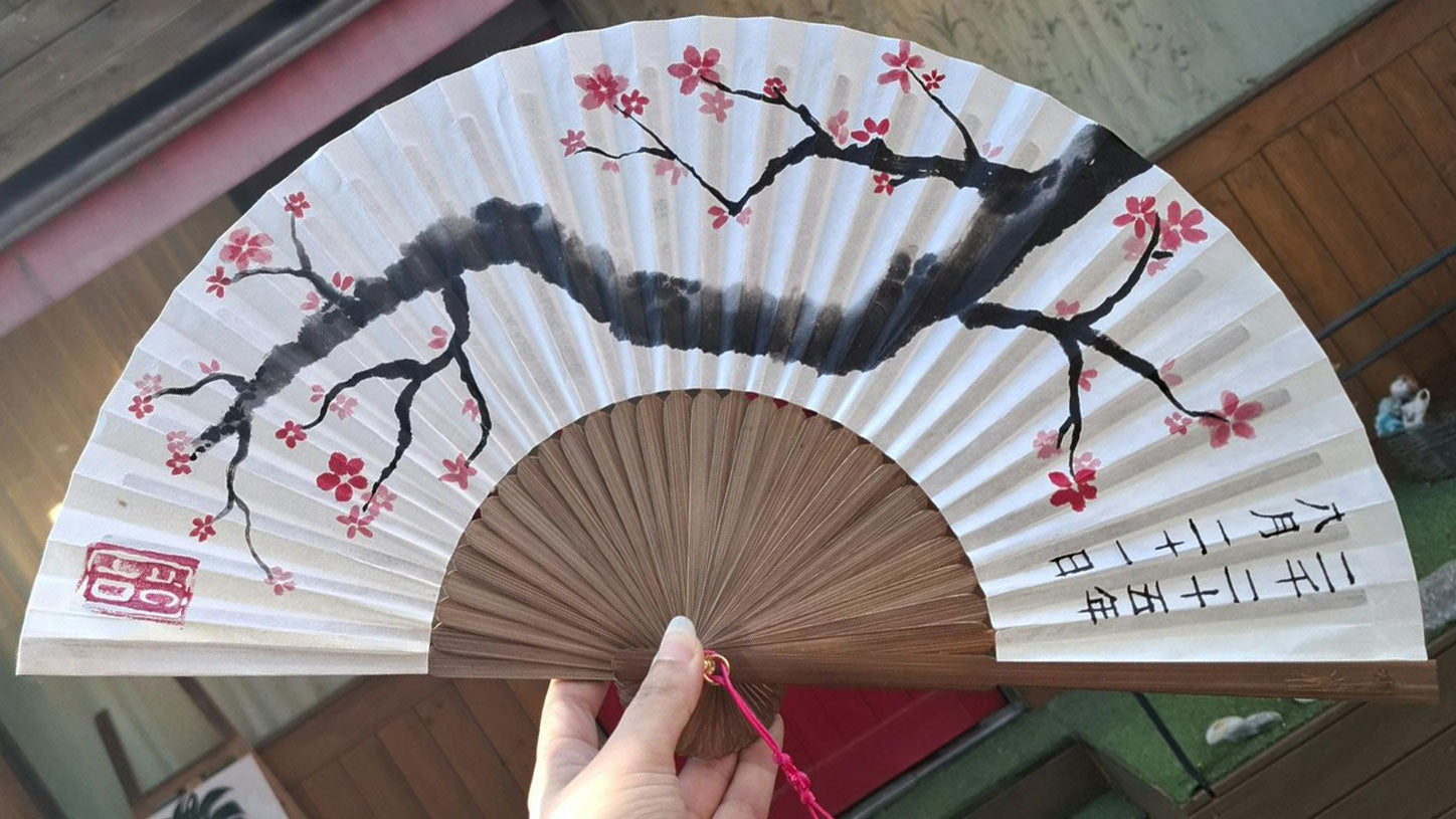 Photo d'un éventail avec un prunier en fleur et la date écrite en caractères chinois